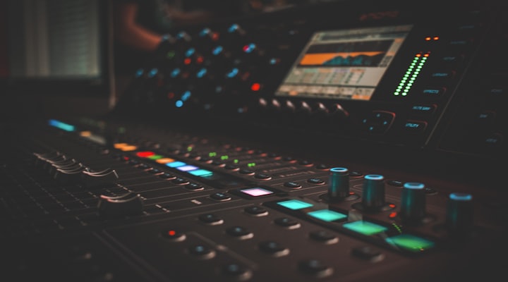 Music production studio console in the dark, LEDs glowing